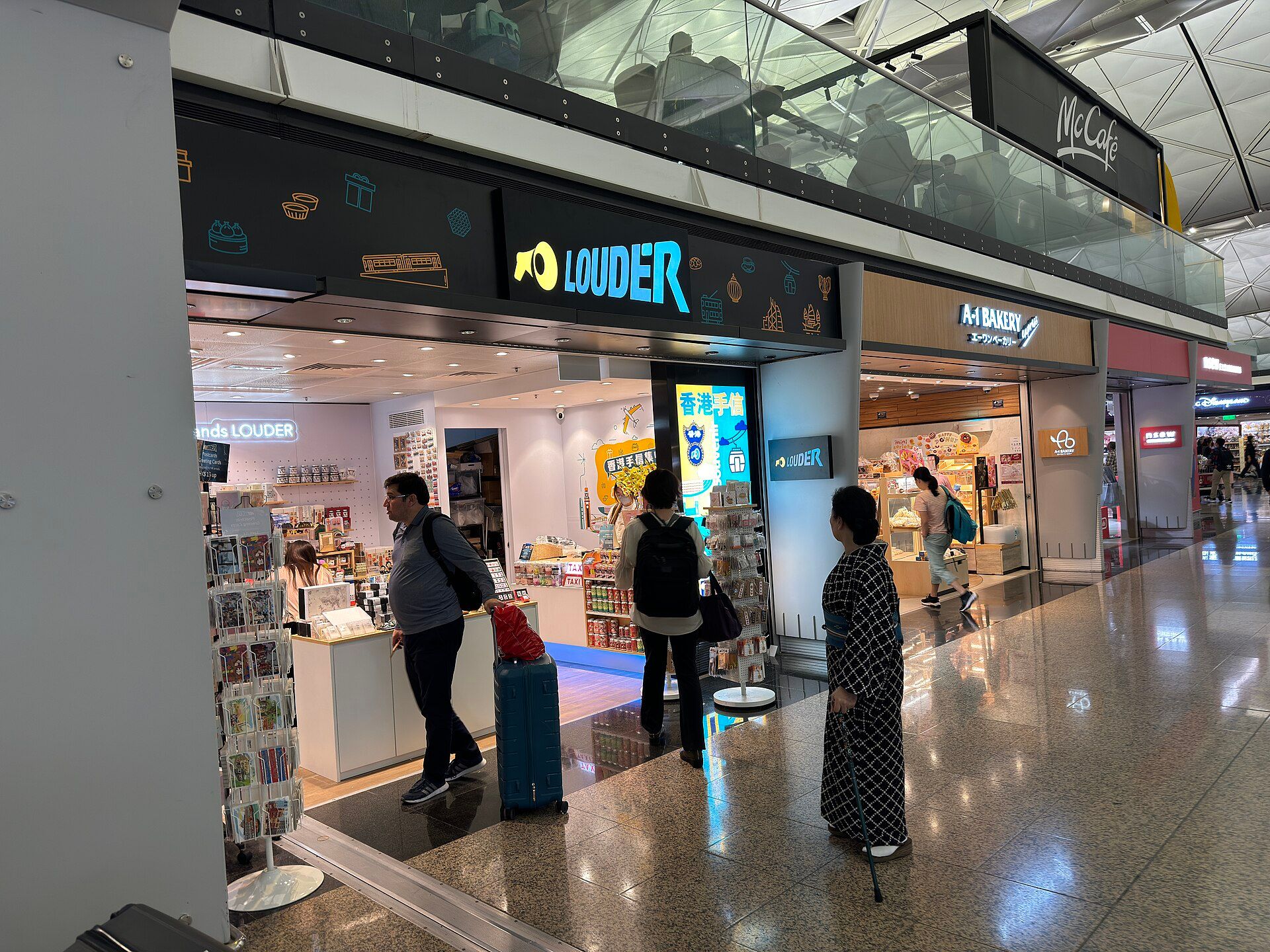 香港機場離境大堂，旅客邊走邊看手機