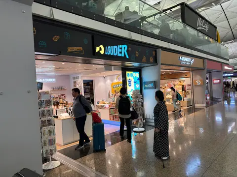 香港機場離境大堂，旅客邊走邊看手機
