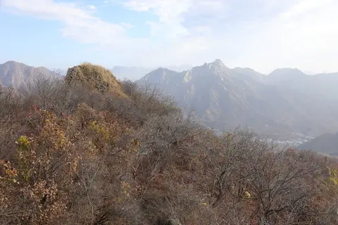 慕田峪長城沿山脊蜿蜒，遊客在城牆上用手機查地圖