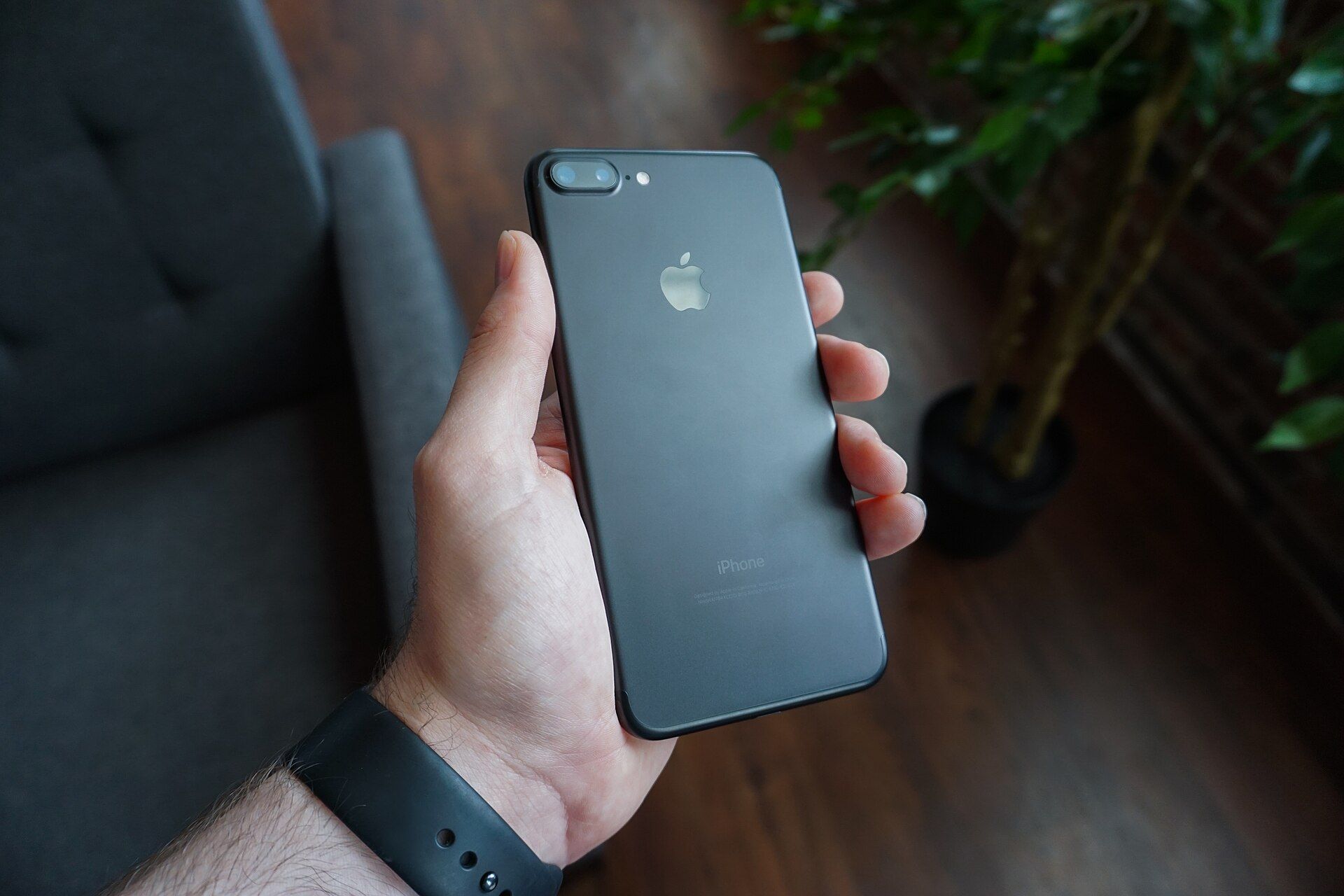 手持 iPhone，螢幕顯示行動服務設定